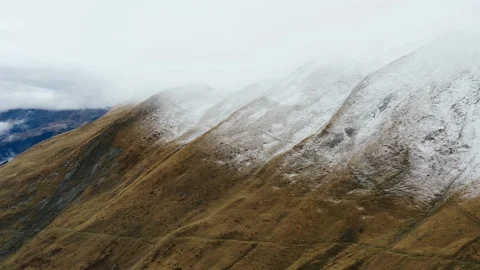 Horizontal landscape view of lightly snow dusted mountains in the clouds Stock Footage 122823405