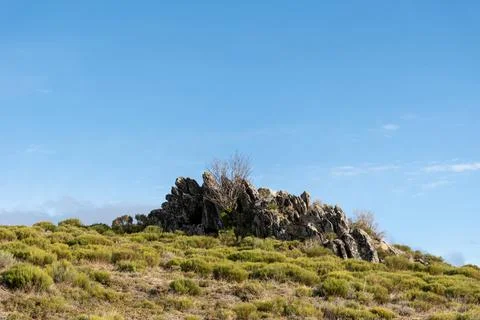Horizontal landscape view of some rocks at the top of a mountain with a green Stock Photos
