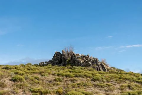 Horizontal landscape view of some rocks at the top of a mountain with a green Stock Photos