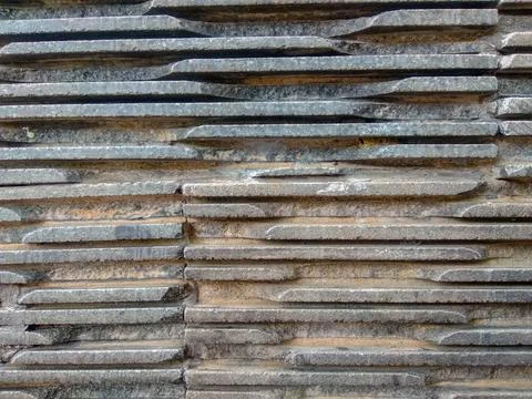 Horizontal layers of stone slabs form this rugged wall Stock Photos