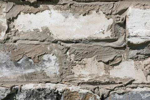 Horizontal masonry, white-gray bricks held together with uneven smudges. 스톡 사진