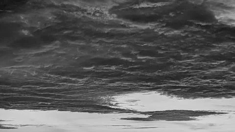 A horizontal monochrome perspective captures dense heavy layers of dark sto.. Stock Photos