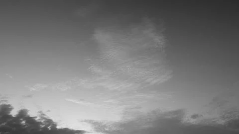 A horizontal monochrome view captures soft light cloud formations floating .. Stock Photos