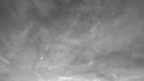 A horizontal monochrome view captures wispy layers of twilight clouds filli.. Stock Photos