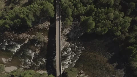 Horizontal overhead aerial view of Bridge of Dee crossing river and wild pine Vídeos de archivo 251045351
