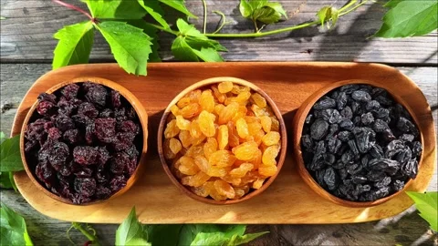Horizontal overhead view of three raisin varieties in wooden bowls on a ser.. Stock Footage 340034479
