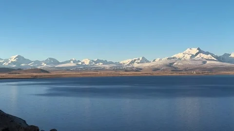 Horizontal pan 50s long shot of Namtso Lake and snow mountains 動画素材 333553577