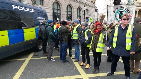 Horizontal pan human chain leading London march police van, peace sign Video stock 171485619