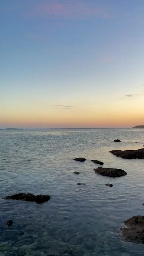 Horizontal Pan Left of Calm Ocean and Pastel Sunset Sky in Bali Stock Footage 337354630