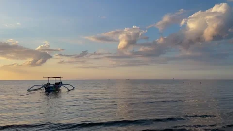 Horizontal Pan Left Revealing Boat on Calm Sea at Sunset in Bali Stock Footage 339276586