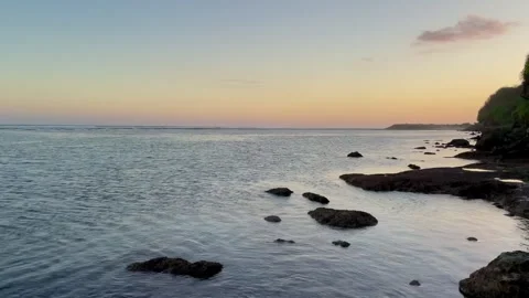 Horizontal Pan Left of Rocky Coast and Cliff During Sunset in Bali Stock Footage 337354454