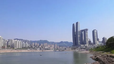 Horizontal pan shot showing Raffles City Chongqing beside Yangtze River Stock Footage 344829729