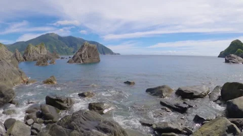 Horizontal pan view look out to pacific ocean horizon from rocky seashore coastl Stock Footage 263020135
