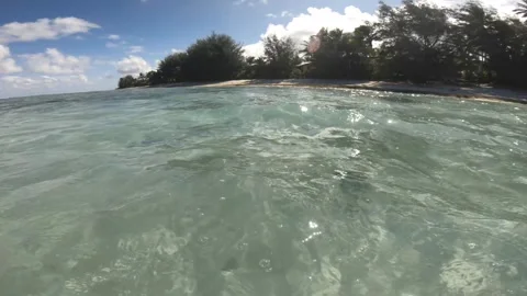 Horizontal pan view of shallow ocean sea salt crystal clear turquoise lagoon loo Stock Footage 245445816