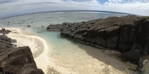 Horizontal pane view of beach side coastline with large and small Basalt black r Stock Footage 235312495