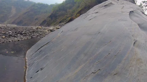Horizontal pane view from a giant boulder rock surround by pond of still water a Stock Footage 265494479
