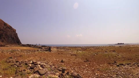 Horizontal pane view look out to Xianglu and Peaked rock from dry rocky shore wi Stock Footage 242997169