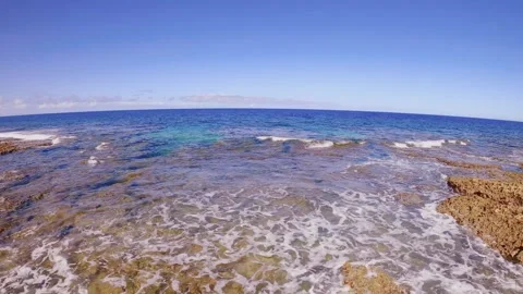 Horizontal pane view look out from rocky coral shore with white wave and current Stock Footage 279143993