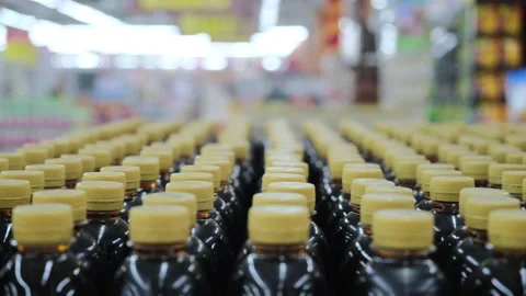 Horizontal panorama of many brown plastic bottles with yellow covers in a row in Video stock 166828291