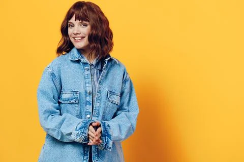Horizontal photo on a yellow background of a nice woman in a stylish denim Stock Photos