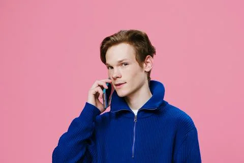 Horizontal portrait of a guy looking at the camera and talking on the phone. Fotos Stock