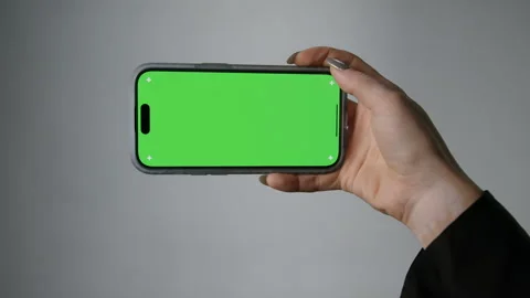 Horizontal position of the smartphone with a green screen, watching content Stock Footage 279730271