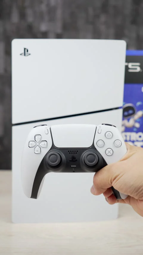 Horizontal PS5 Slim Standing in Front of Astro Bot and Gran Turismo 7 Box Stock Footage 345056972