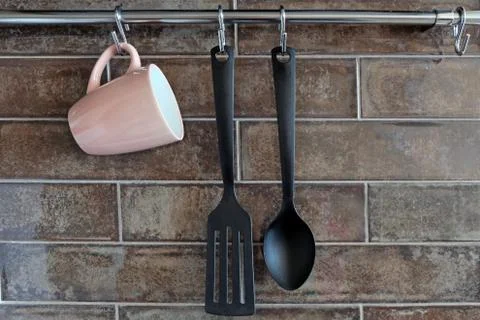 Horizontal railing on the background of ceramic tiles in the kitchen. A pink Stock Photos