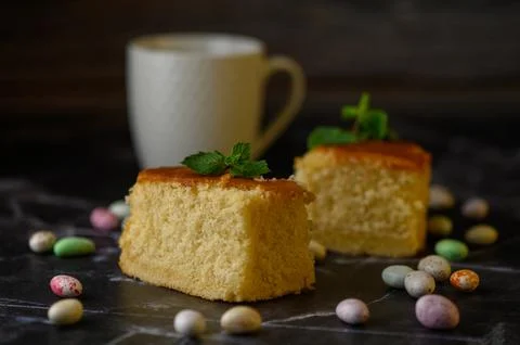 Horizontal rustic tabletop photograph of two slices of sponge cake, colorfu.. Stock Photos