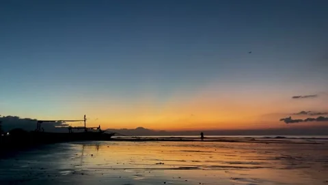 Horizontal shot of beach dawn with sunbeams and boat silhouette in Bali Vidéo 343796799