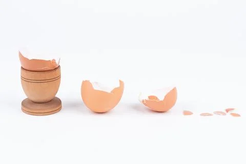 Horizontal shot of broken egg shell in old wooden egg stand and multiple other Stock Photos