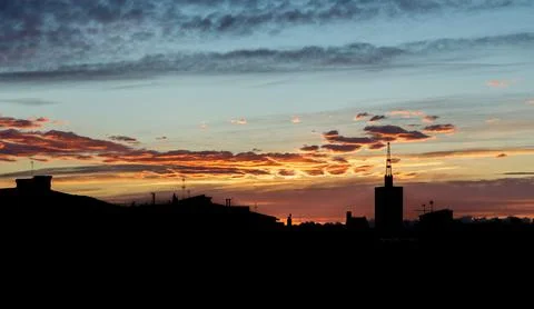 Horizontal shot of clouds floating across the sky with the setting sun on a Photos