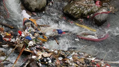 Horizontal shot of river current passing through plastic litter. Stock Footage 336314114