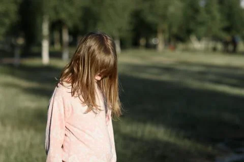 Horizontal shot side view of standing girl, a teenager thinks. Stock Photos