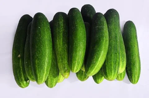 Horizontal shot of a stack of cucumbers places vertically on a white backgrou 스톡 사진