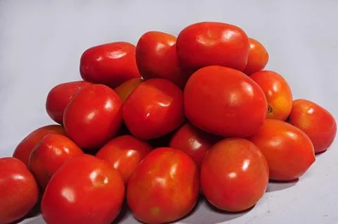 Horizontal shot of a stack of red cherry tomatoes on a white background Stock Photos