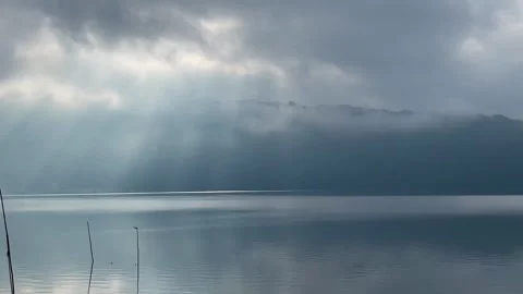Horizontal Shot of Sun Rays Shining Over Misty Mountain Lake Stock Footage 341039003
