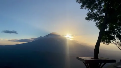 Horizontal Shot of Sunbeams Bursting Behind Mount Agung at Sunrise Video stock 341552138