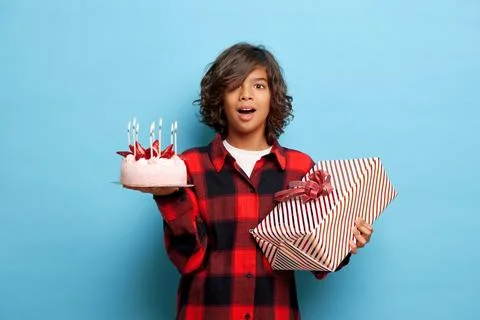 Horizontal shot of surprised dark skinned young guy holds birthday cake with Stock-Fotos