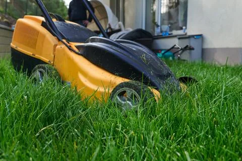 Horizontal side view lawn mower parked on lawn Stock Photos