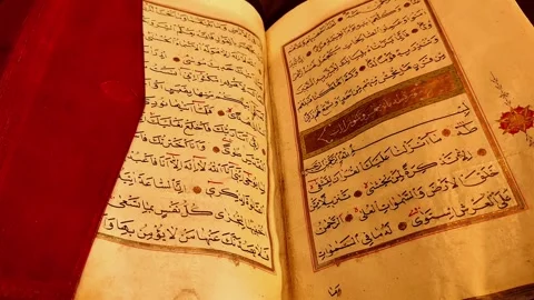 Horizontal slow tilt-up shot of an open ancient Quran. Gradually revealing the Vídeos de archivo 334029439