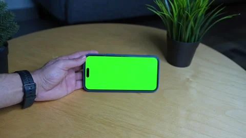 Horizontal Smartphone with Green Screen – Handheld Chroma Key Setup on Wooden Stock Footage 309944550