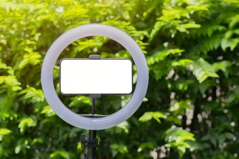 Horizontal smartphone with led ring lamp over on real nature background wit.. Stock Photos