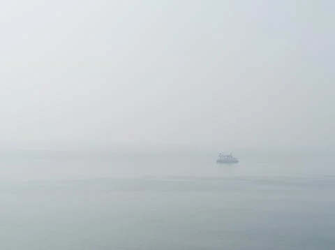 Horizontal sparse pale lonely ship in white ocean background bac Stock Photos