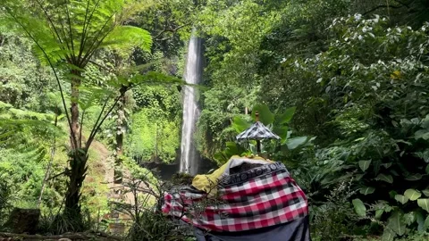 Horizontal Static Shot of Balinese Shrine and Tall Waterfall Stock Footage 340562516