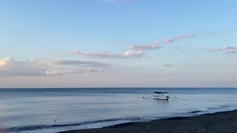 Horizontal Static Shot of Boat Anchored on Bali Black Sand Beach Stock Footage 340411421