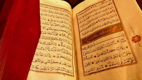 Horizontal static shot of an open handwritten Quran. Focuses on the detailed Vídeos de archivo 334029440