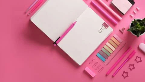 Horizontal stationery background with open notebook with stationery in pink t Stock Photos