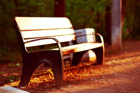 Horizontal sunset park bench in light bokeh background Stock Photos
