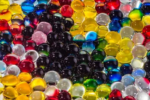 A horizontal texture of a group of multi-colored transparent hydrogel balls Stock Photos